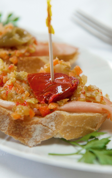 Tranches de baguette grillées avec rondelles de salami et aubergines marinées piquantes